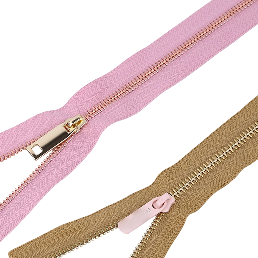 Two custom zinc alloy zipper slider variations with polished gold and painted pink electroplating finish.