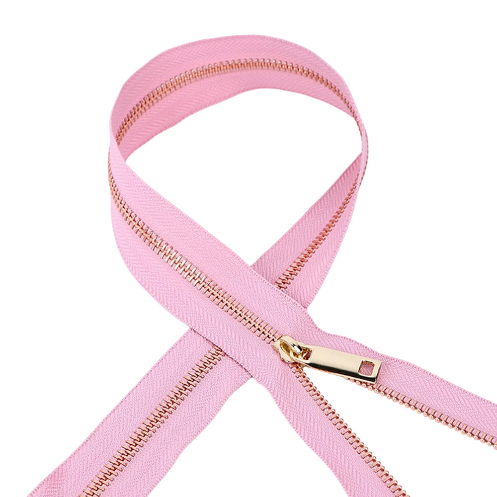 Premium gold pull tab from a luxury bag zipper hardware supply on a looped pink zipper tape.