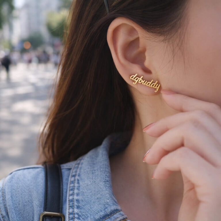 Gold plated name earrings with elegant script word design on a white background.