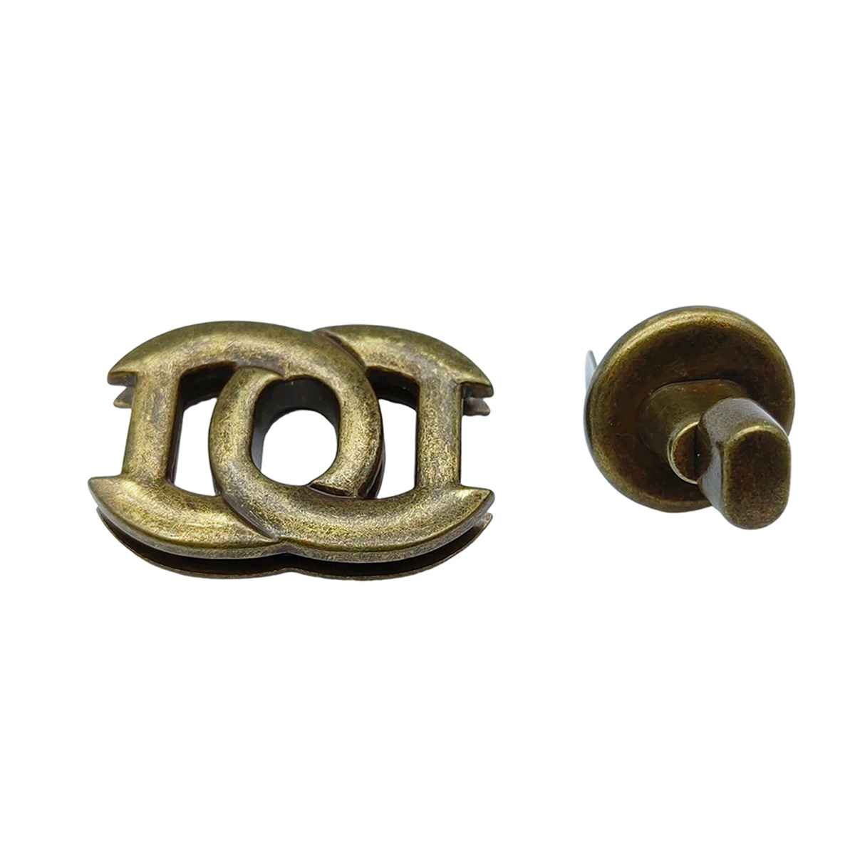 Disassembled parts of antique brass handbag turn lock components including the front plate and twist mechanism.