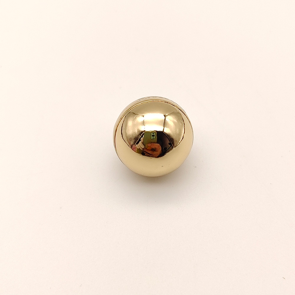 Close up view of a solid metal ball charm with a flawless mirror polish finish.