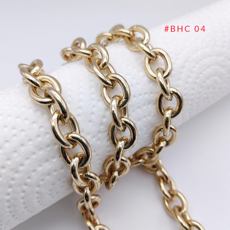 Close-up of thick oval link metal bag chain with a high-quality polished light gold finish.