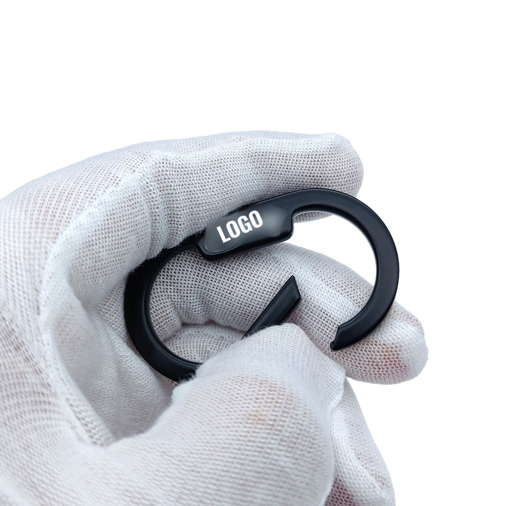 Logo spring gate ring held in hand with gate open for strap threading