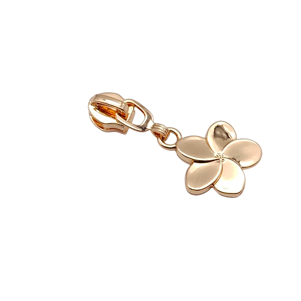 Light gold flower zipper slider showing the articulated connector and four-petal pull tab