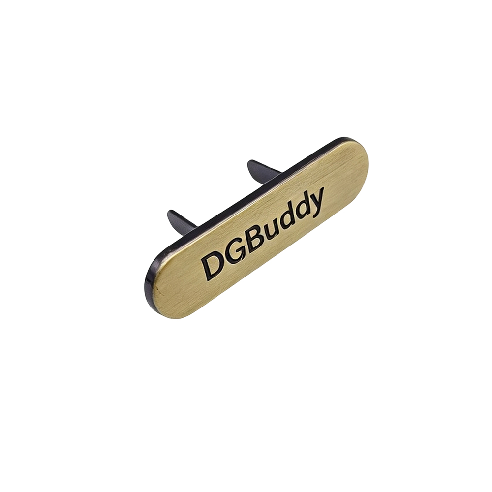 Angled view of antique gold handbag metal logo plate with raised lettering
