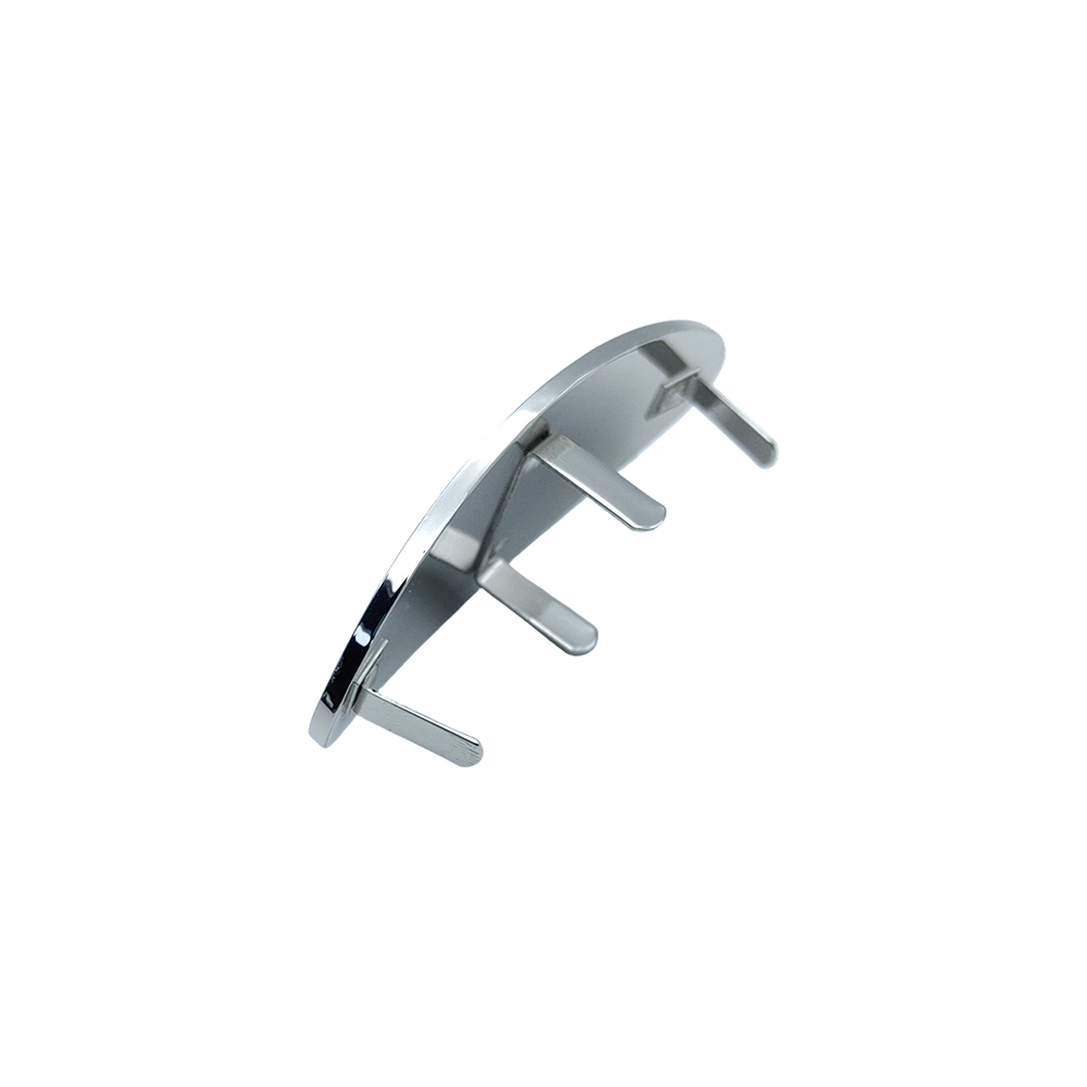 Back view of a prong-mounted bag logo plate with four metal attachment prongs