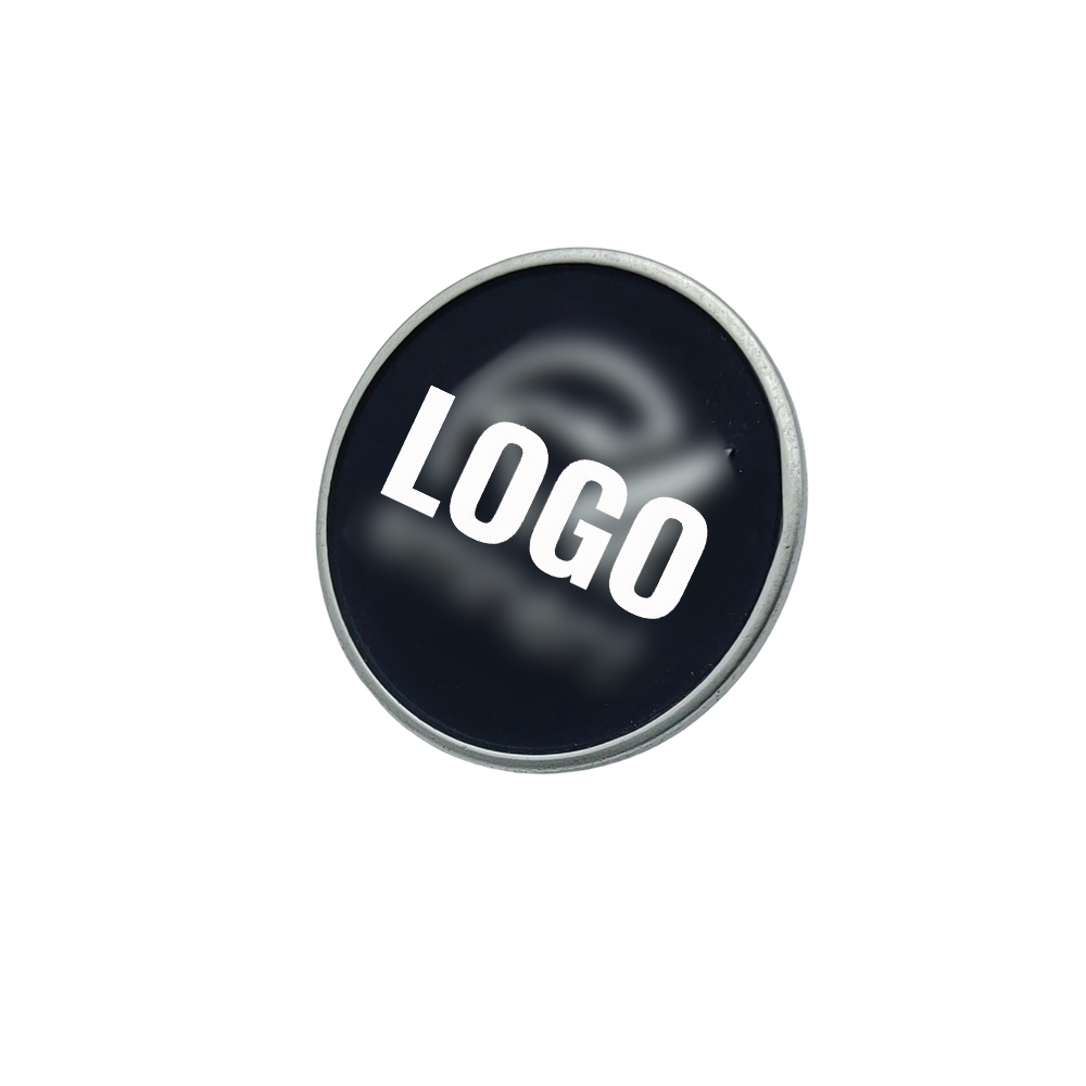 Round metal logo tag with custom white logo on a black recessed background
