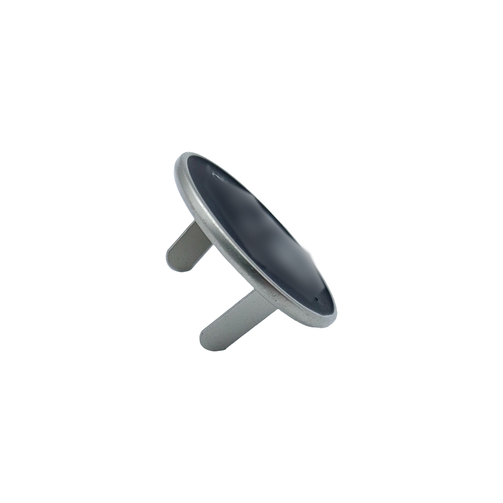 Angled view of round metal logo tag with two rear pins for leather bag branding