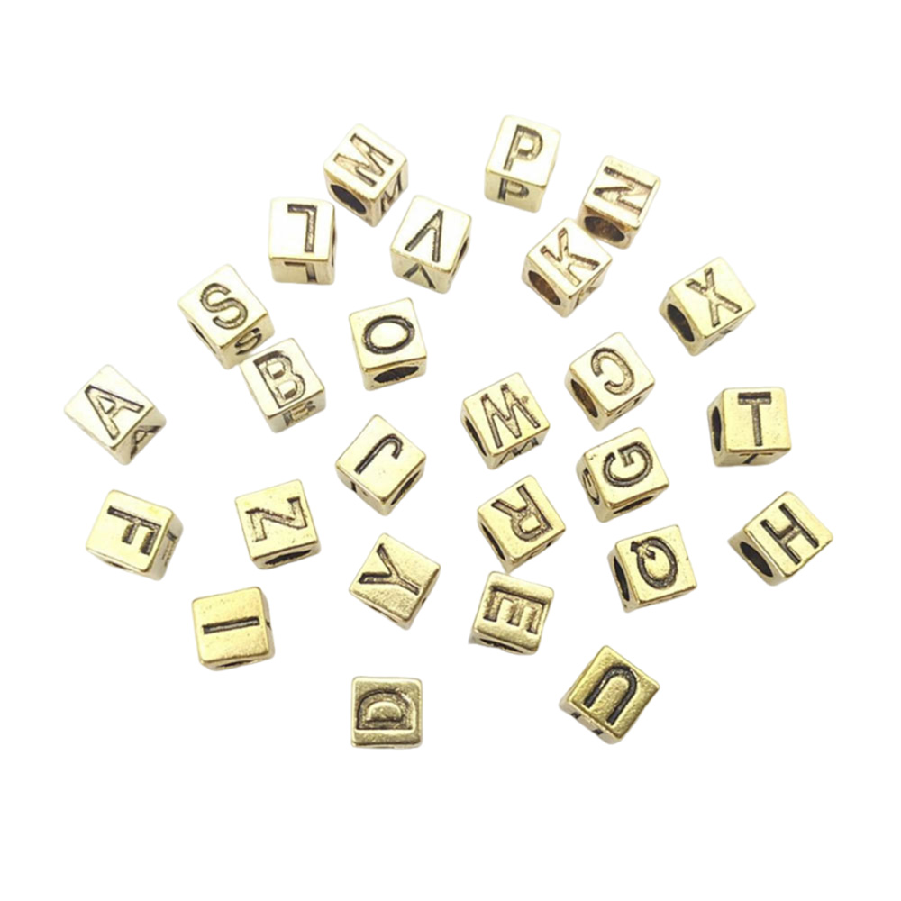 antique gold metal initial beads shown as individual recessed alphabet letters