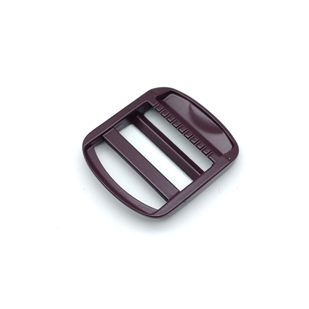Close angled detail of backpack strap ladder lock focusing on the toothed bar and slot entry edges