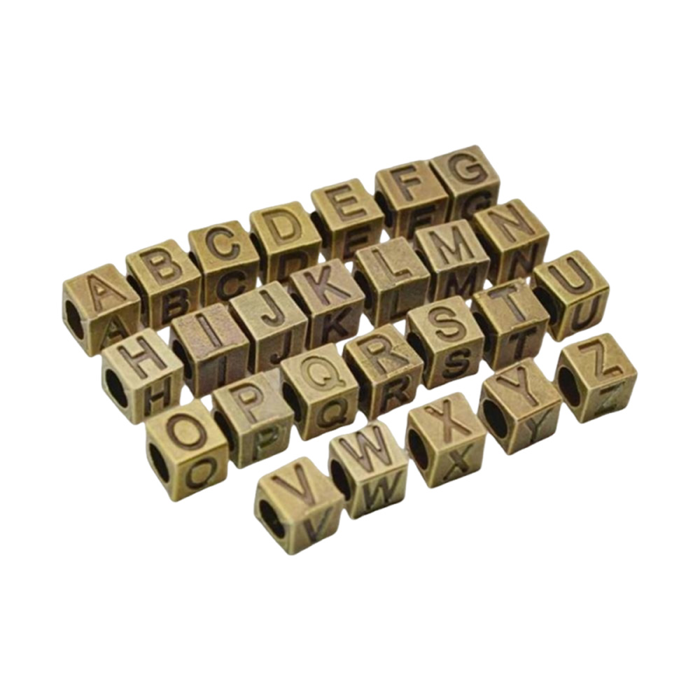 bulk metal letter beads arranged in rows for alphabet selection and jewelry production