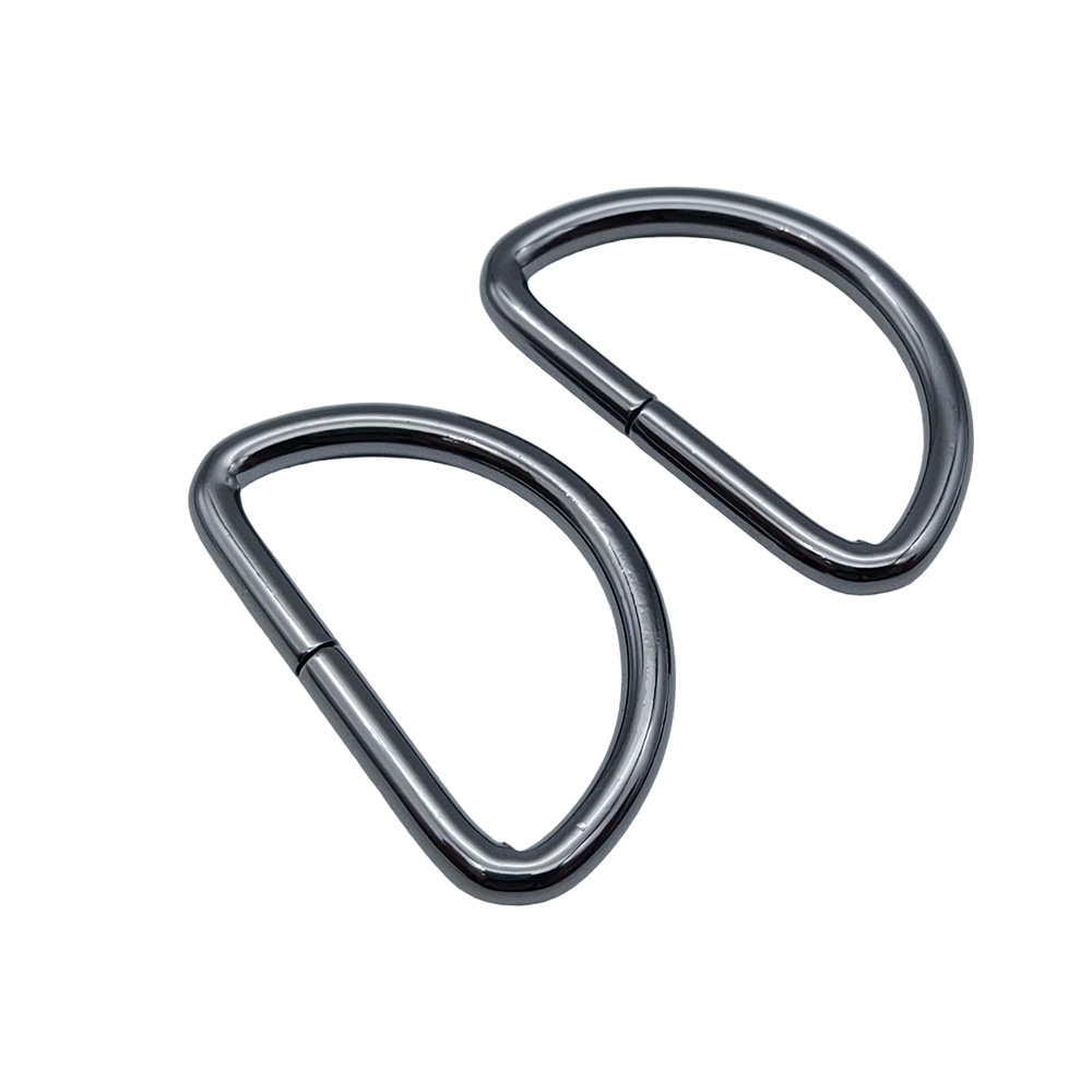 Two iron d ring webbing connectors with gunmetal plating arranged diagonally on white