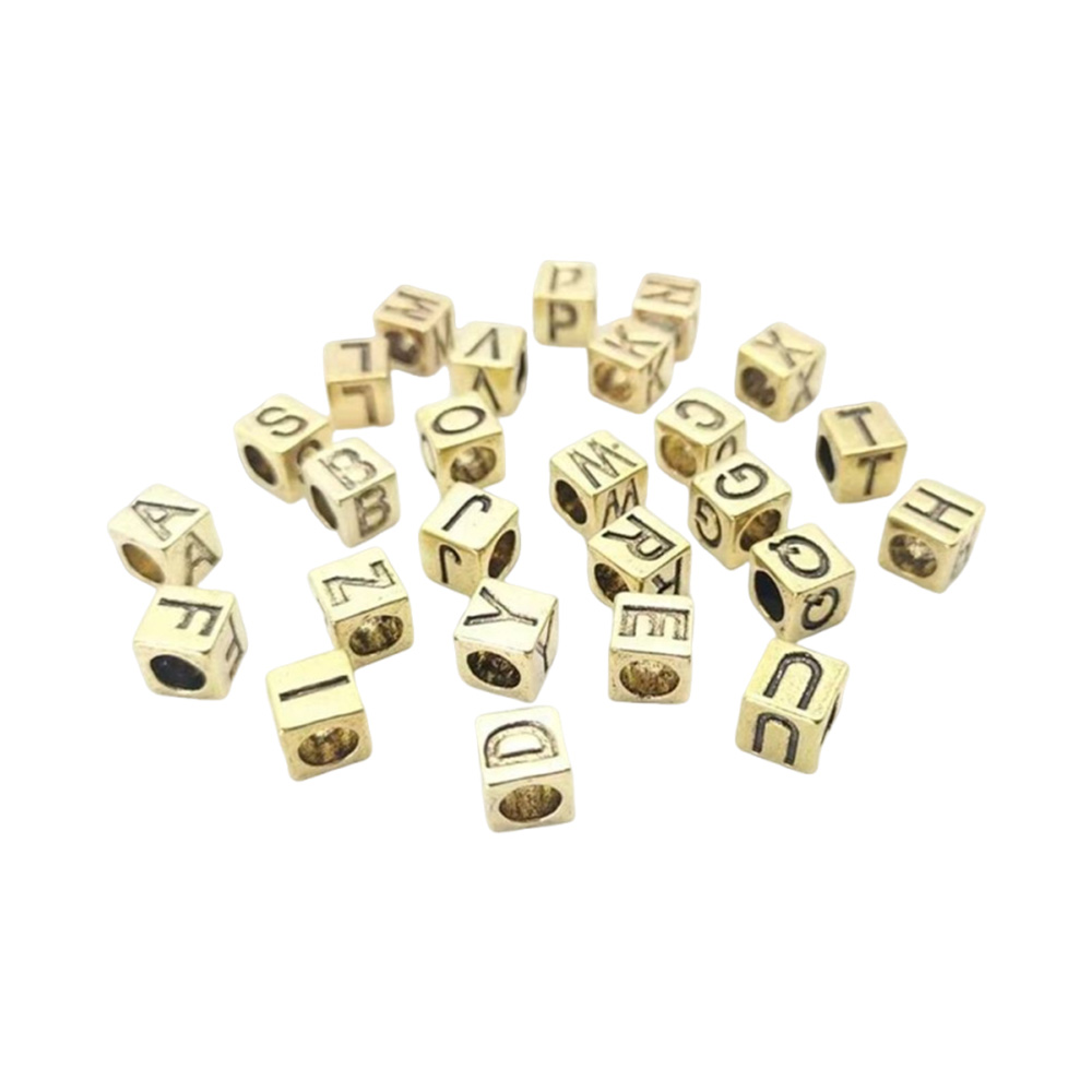 close view of recessed letters on antique gold zinc alloy cube beads